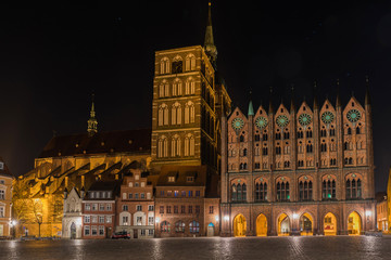 Stralsund – Rathaus mit Schaufassade, dahinter die Nikolaikirche am Alten Markt bei Nacht