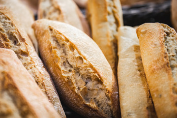 Homemade breads cooked in wood-fired oven as formerly yummy. Delicious large breads packed with flour in a basket