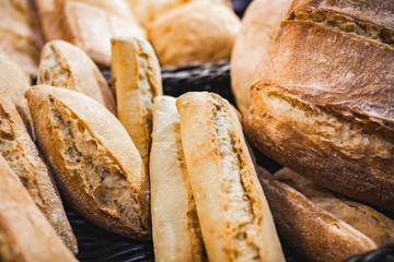 Homemade breads cooked in wood-fired oven as formerly yummy. Delicious large breads packed with flour in a basket