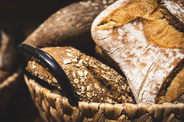 Homemade breads cooked in wood-fired oven as formerly yummy. Delicious large breads packed with flour in a basket