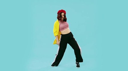 Happy plump young woman in trendy clothing dancing