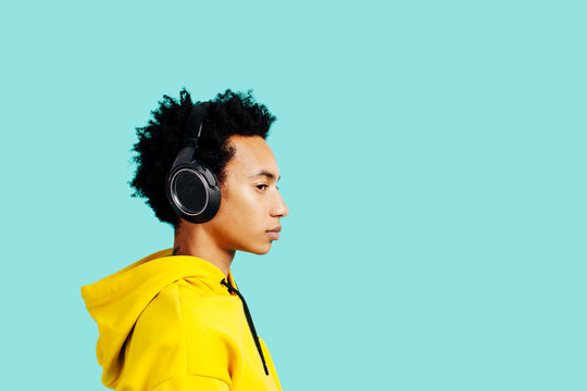 Profile portrait of a young man with headphones listening to music 