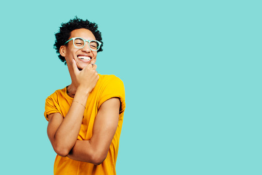 Portrait Of A Smiling Young Man With Eyes Closed, Isolated On Blue Background