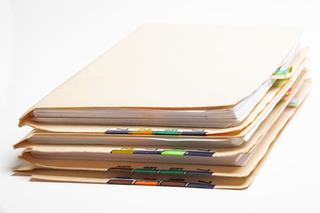 A stack of color-coded and numbered yellow file folders containing sheets of papers, files and...