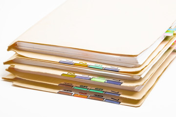 A stack of color-coded and numbered yellow file folders containing sheets of papers, files and documents set on a white background.