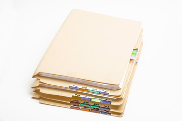 A stack of color-coded and numbered yellow file folders containing sheets of papers, files and documents set on a white background.