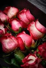 red roses and heart on wooden background