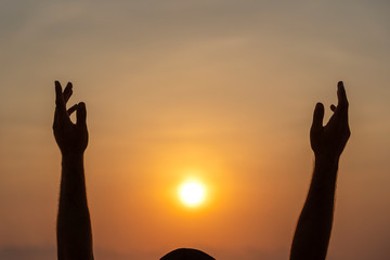 Man raised his hands during sunset