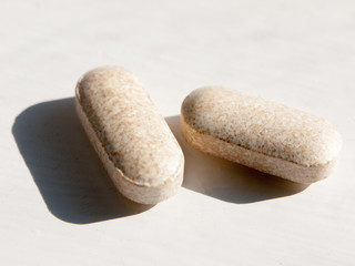 close up of two tablets on white background health vitamins