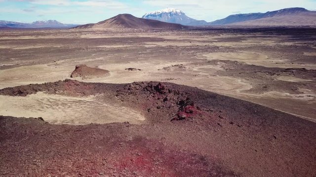 Spectacular aerial over red ash topped volcanoes and lava flows in the remote highland interior of Iceland.