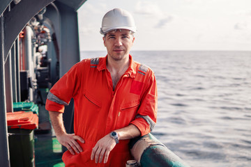 Marine chief officer or chief mate on deck of ship or vessel. He is looking at the camera. He looks...