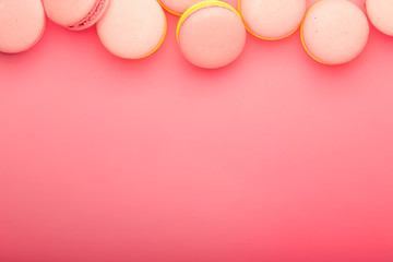 Pink yellow macaroons on soft pink background table, place for text, minimalism style, top view