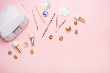 Beauty accessories for manicure and pedicure on a pink background,. Samples of nail polish, scissors, manicure ultraviolet machine, nippers and other accessories for home and salon procedures