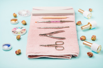 Manicure tools on a pink towel and a blue background. Manicure background.