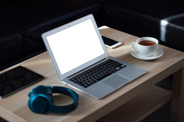 Laptop and cup of tea on the wooden table