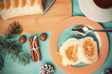 Sweet roll with whipped cream and tangerine filling and Christmas decorations