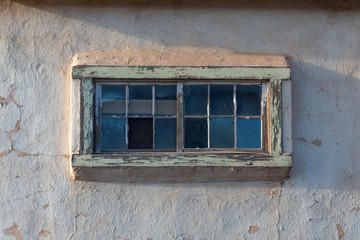 Wood frame window set into an old adobe house, centered, American Southwest, horizontal aspect