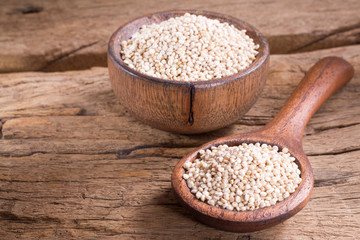 Quinoa seeds in bowl on rustic wood