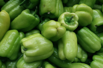 Many scattered ripened green pepper fruits in the store