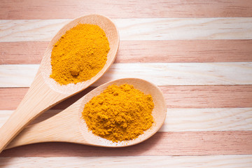 Turmeric powder on wooden background