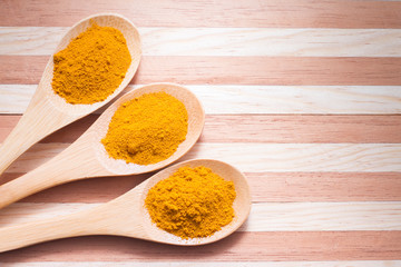 Turmeric powder on wooden background