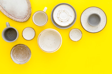 Ceramic tableware pattern. Empty plates and mugs on yellow background top view space for text