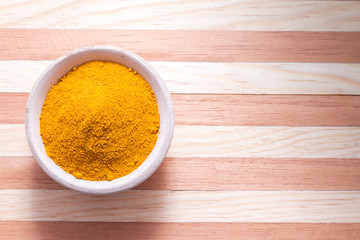 Turmeric powder on wooden background