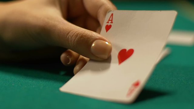Casino croupier turning over ace of hearts, fortune sign in poker game, victory