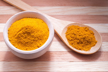 Turmeric powder on wooden background