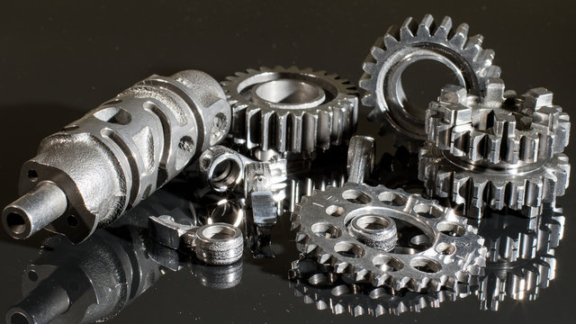 transmission parts from a race motorcycle engine on a reflective background