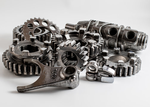 transmission parts from a race motorcycle engine on a reflective background