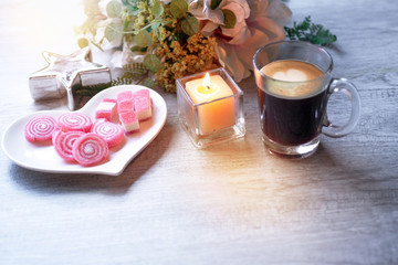 Sweet jelly in heart shaped plate for valentine's day with candle, silver star and a cup of black coffee, on wood background