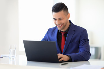 Smiling business man working with laptop at office