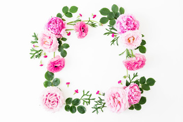 Frame of pink peonies flowers, roses and leaves on white background. Floral lifestyle composition. Flat lay, top view.