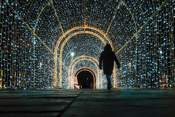Gdansk, Poland Christmas decorations in a light tunnel at the Forum Mall and pedestrians.
