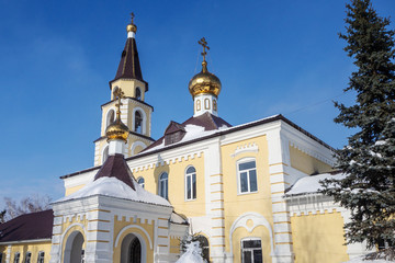 Fototapeta na wymiar Orthodox temple with gold crosses and domes against the blue sky. Winter.