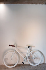 Retro bicycle on the concrete white wall 