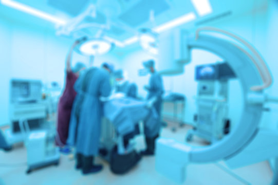 Blur of group of veterinarian surgery in operation room take with art lighting and blue filter