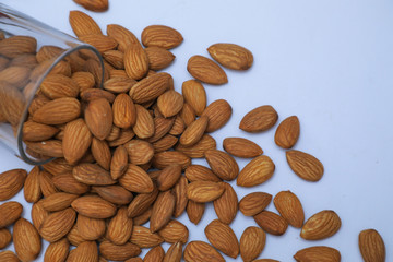 almonds on glass with white background, Indian almonds in white background, almonds were splatted out from the glass