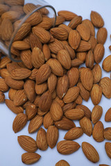 almonds on glass with white background, Indian almonds in white background, almonds were splatted out from the glass