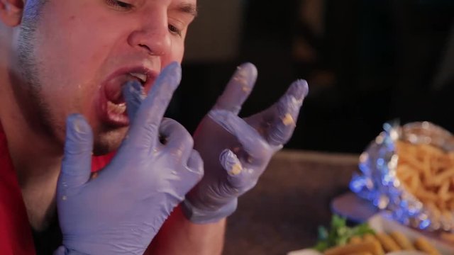 Man licking his hands after eating.