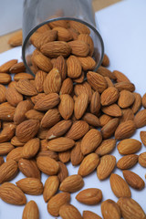 almonds on glass with white background, Indian almonds in white background, almonds were splatted out from the glass