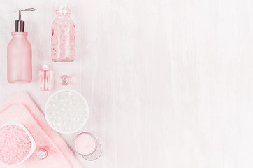 Elegance pink spa cosmetic products for skin and body care on soft white wood background, copy space, flat lay.