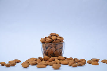 Fototapeta na wymiar almonds on glass with white background, Indian almonds in white background
