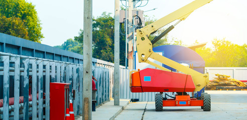 construction worker at construction site using lifting boom machinery 