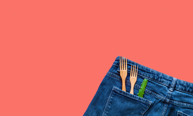 Creative Coral background with wooden forks on denim texture. 