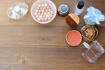 Cosmetics, perfume, cream and candles on wooden background. Female background.