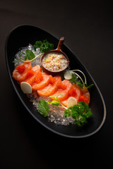 Salmon spicy On a black plate. Salmon spicy On a black background