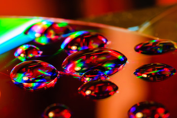 light and water droplets on cd plate