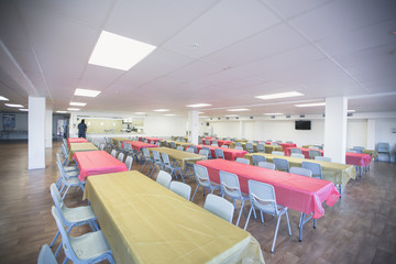 Tables set up plates and decorations in a hindu temple getting ready for a dinner